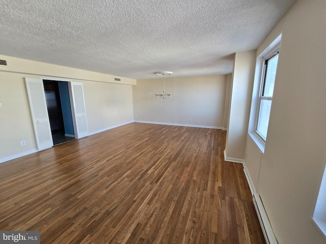 1101 Saint Paul St Unit 1212, Baltimore, MD 21202 - unfurnished room with dark wood-style floors, a chandelier, a textured ceiling, and a baseboard heating unit