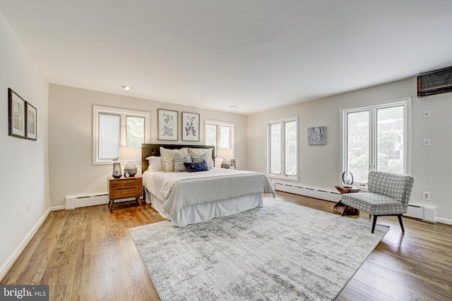 4110 Ingomar St NW, Washington, DC 20015 - bedroom featuring a baseboard heating unit, light wood-style floors, and an AC wall unit