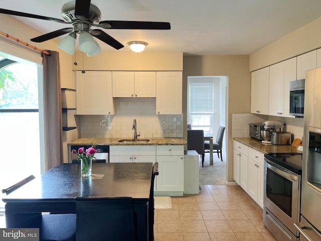 203 Spring Dr, Voorhees, NJ 08043 - kitchen featuring appliances with stainless steel finishes, backsplash, a ceiling fan, white cabinetry, and light tile patterned floors