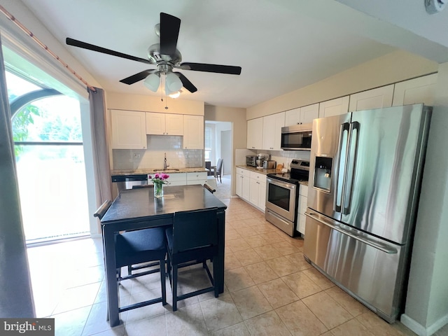 203 Spring Dr, Voorhees, NJ 08043 - kitchen with appliances with stainless steel finishes, decorative backsplash, white cabinets, ceiling fan, and light tile patterned floors