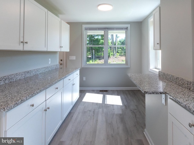 2450 Happy Creek Rd, Front Royal, VA 22630 - kitchen with wood finished floors, white cabinetry, and light stone countertops