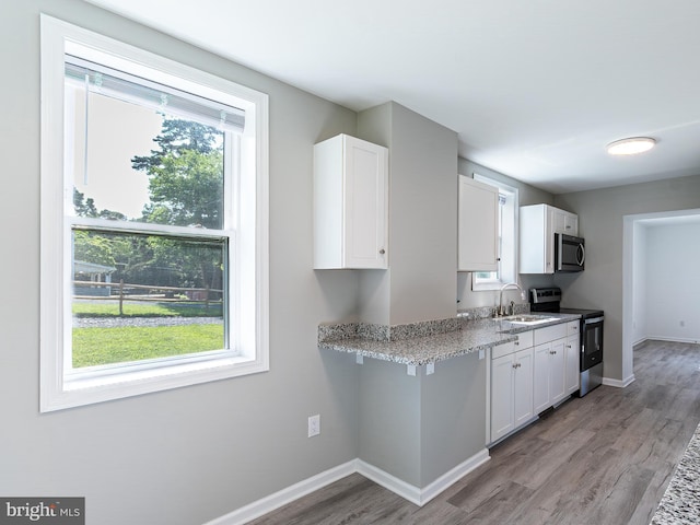 2450 Happy Creek Rd, Front Royal, VA 22630 - kitchen with appliances with stainless steel finishes, white cabinets, wood finished floors, and light stone countertops