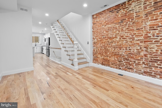 2002 E Lafayette Ave, Baltimore, MD 21213 - staircase with wood finished floors, recessed lighting, and brick wall