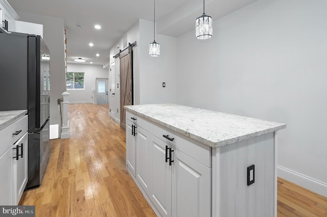 2002 E Lafayette Ave, Baltimore, MD 21213 - kitchen with freestanding refrigerator, a barn door, light wood finished floors, a kitchen island, and recessed lighting