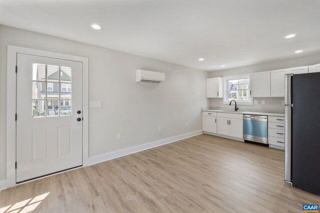 1603 Griffen Grv, Charlottesville, VA 22901 - kitchen with appliances with stainless steel finishes, an AC wall unit, light countertops, light wood-style flooring, and white cabinetry
