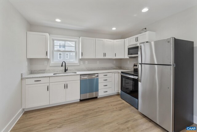 1603 Griffen Grv, Charlottesville, VA 22901 - kitchen with stainless steel appliances, white cabinets, light stone countertops, light wood-type flooring, and recessed lighting
