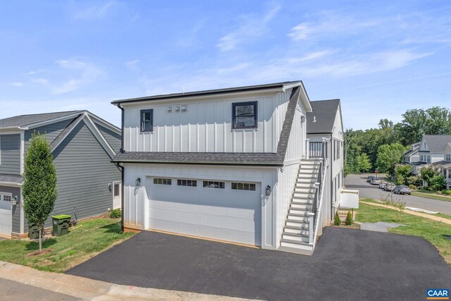 1603 Griffen Grv, Charlottesville, VA 22901 - view of front of home featuring board and batten siding, asphalt driveway, stairs, a garage, and a shingled roof