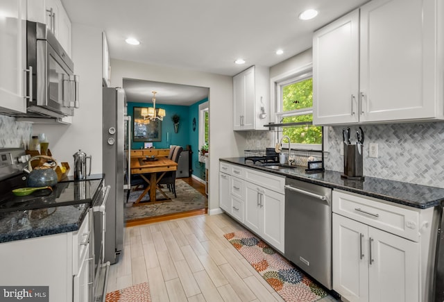 124 Connecticut Ave, Cherry Hill, NJ 08002 - kitchen featuring appliances with stainless steel finishes, a chandelier, light wood-type flooring, white cabinetry, and decorative backsplash