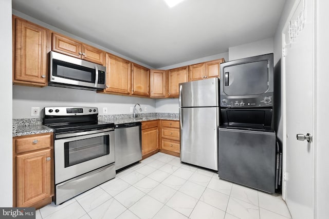 12001 Old Columbia Pike Unit 305, Silver Spring, MD 20904 - kitchen with stainless steel appliances, stacked washer / drying machine, and light stone counters
