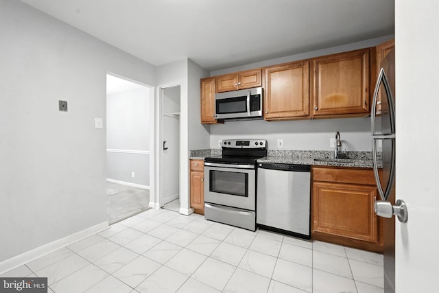 12001 Old Columbia Pike Unit 305, Silver Spring, MD 20904 - kitchen with appliances with stainless steel finishes, stone countertops, and brown cabinets