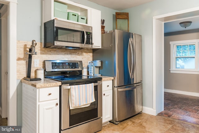 850 N Reading Ave, Boyertown, PA 19512 - kitchen featuring appliances with stainless steel finishes, light stone finish floors, decorative backsplash, and white cabinetry