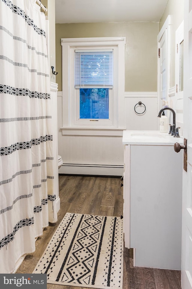 850 N Reading Ave, Boyertown, PA 19512 - full bathroom featuring vanity, wainscoting, a baseboard radiator, wood finished floors, and curtained shower
