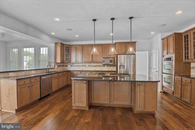 13319 Moonlight Trail Dr, Silver Spring, MD 20906 - kitchen featuring stainless steel appliances, brown cabinetry, a center island, dark wood-style flooring, and decorative backsplash