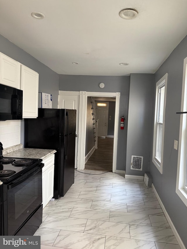1631 Cotton St, Reading, PA 19606 - kitchen with black appliances, white cabinets, light marble finish floors, backsplash, and recessed lighting
