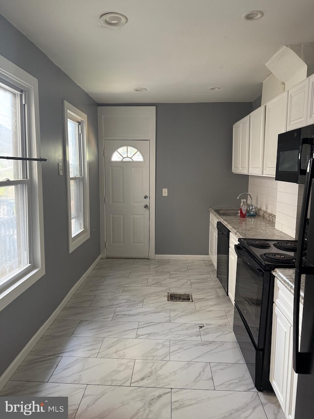 1631 Cotton St, Reading, PA 19606 - kitchen with black appliances, white cabinets, backsplash, light marble finish floors, and recessed lighting