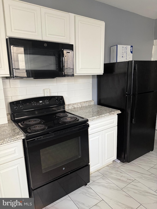 1631 Cotton St, Reading, PA 19606 - kitchen with black appliances, light marble finish floors, white cabinetry, decorative backsplash, and light stone countertops