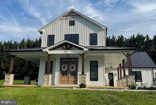 4340 Lee Rd, Glenville, PA 17329 - modern farmhouse featuring covered porch, board and batten siding, a front yard, and a metal roof