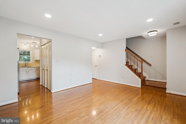 10 Suncroft Ct, Silver Spring, MD 20904 - unfurnished living room featuring light wood-style flooring, stairway, rail lighting, and recessed lighting