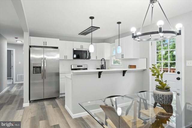 1415 Larch Rd, Severn, MD 21144 - kitchen with stainless steel appliances, a chandelier, light wood-style floors, and a peninsula