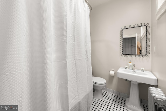 619 E 36th St E, Baltimore, MD 21218 - bathroom featuring radiator heating unit, a shower with shower curtain, and tile patterned flooring