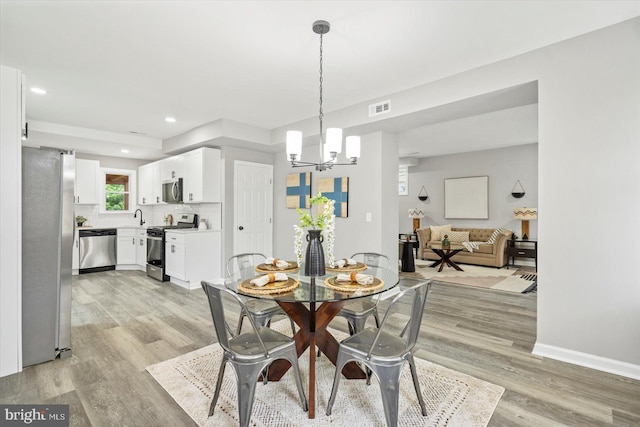 3912 Fernhill Ave, Baltimore, MD 21215 - dining room featuring a chandelier, light wood-style flooring, and recessed lighting