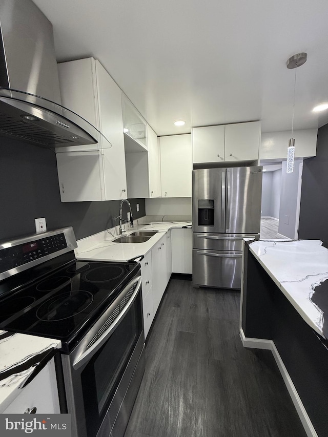 331 Spring Garden St, Reading, PA 19602 - kitchen with stainless steel appliances, wall chimney range hood, white cabinets, dark wood-style floors, and pendant lighting