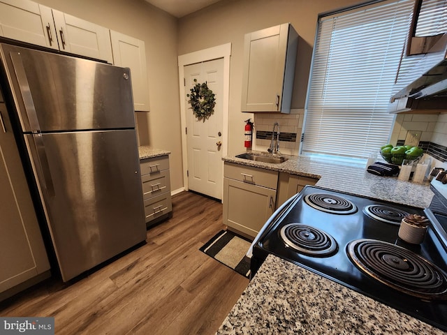 335 N 60th St, Philadelphia, PA 19139 - kitchen featuring freestanding refrigerator, electric range, backsplash, wood finished floors, and light stone counters