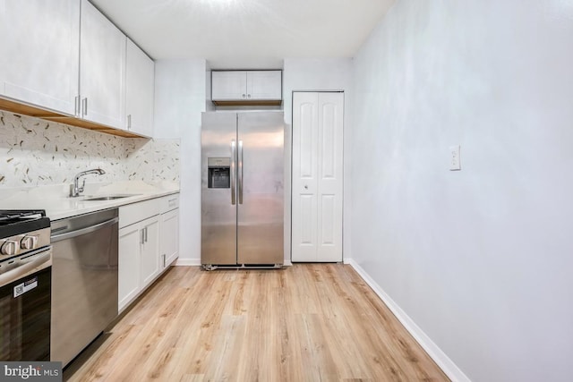 1836 Metzerott Rd Unit 419, Hyattsville, MD 20783 - kitchen featuring stainless steel appliances, light wood-type flooring, white cabinetry, backsplash, and light countertops