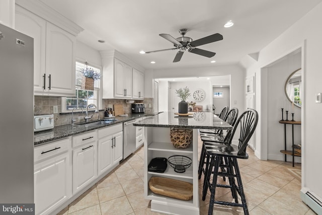 405 Frances Ave, Linwood, NJ 08221 - kitchen with appliances with stainless steel finishes, a baseboard heating unit, open shelves, decorative backsplash, and a breakfast bar