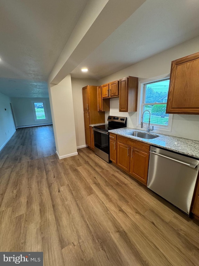 5825 Ebenezer Rd, White Marsh, MD 21162 - kitchen featuring stainless steel appliances, light wood-style floors, brown cabinetry, light stone counters, and recessed lighting