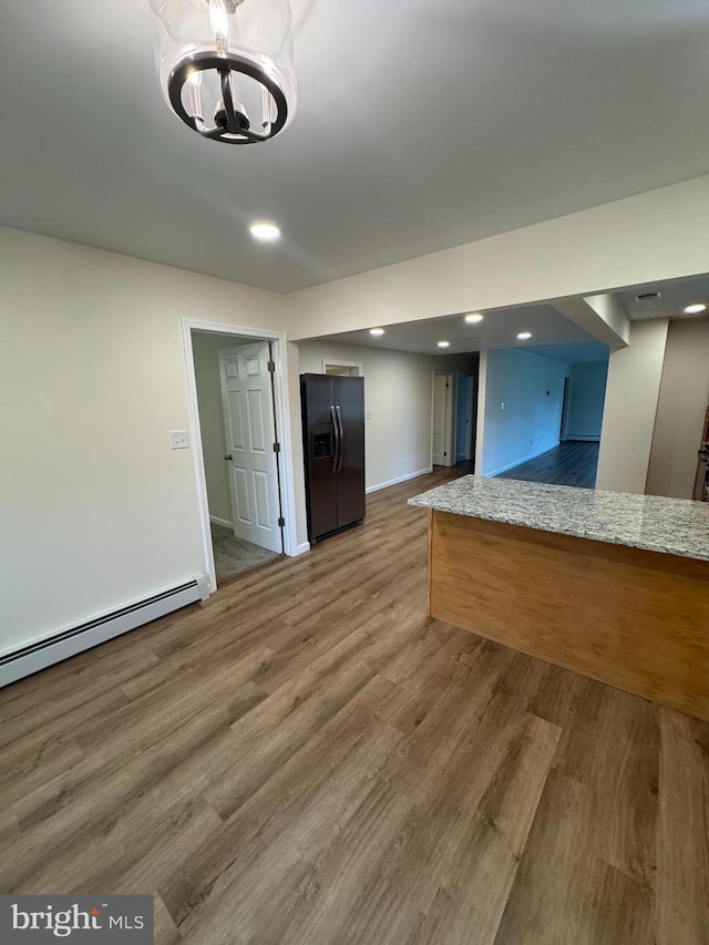 5825 Ebenezer Rd, White Marsh, MD 21162 - kitchen with black fridge, wood finished floors, a chandelier, recessed lighting, and a baseboard heating unit