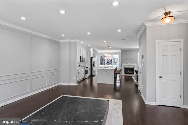 6692 Ordsall St, Alexandria, VA 22315 - living room with ornamental molding, dark wood-style flooring, a glass covered fireplace, recessed lighting, and a chandelier