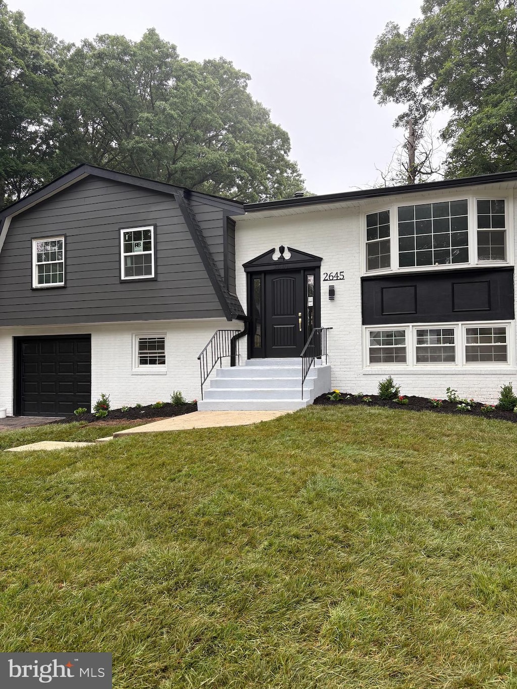 2645 Pinewood Dr, Waldorf, MD 20601 - view of front of home featuring brick siding, a garage, a gambrel roof, and a front lawn