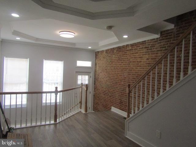 16 Gilmor St, Baltimore, MD 21223 - entrance foyer with brick wall, a tray ceiling, wood finished floors, ornamental molding, and recessed lighting