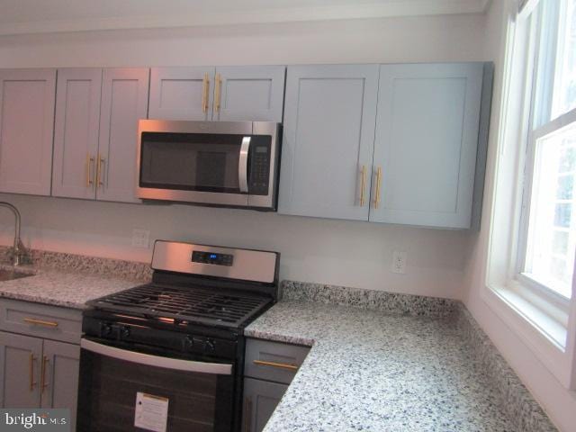 16 Gilmor St, Baltimore, MD 21223 - kitchen featuring stainless steel appliances, gray cabinets, and light stone counters