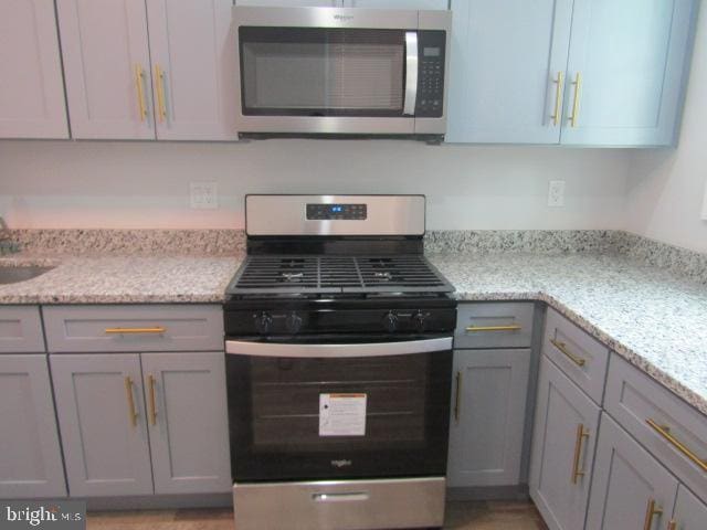 16 Gilmor St, Baltimore, MD 21223 - kitchen with stainless steel appliances, gray cabinets, and light stone countertops