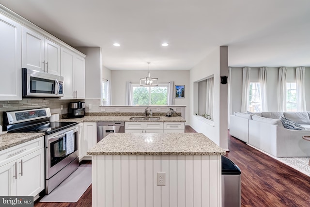 43865 Laurel Ridge Dr, Ashburn, VA 20147 - kitchen featuring appliances with stainless steel finishes, white cabinetry, dark wood finished floors, a center island, and open floor plan