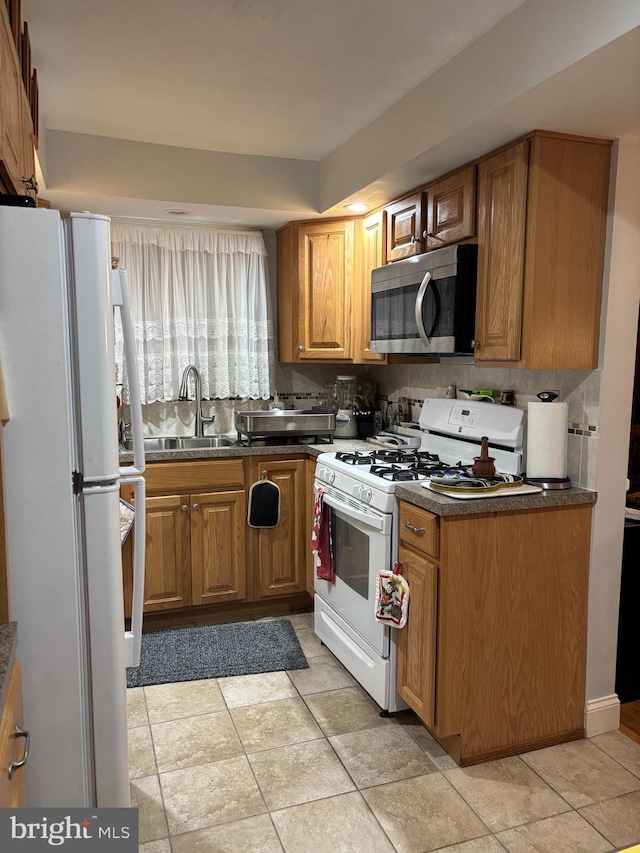 823 Church Ln, Lansdowne, PA 19050 - kitchen with white appliances, dark countertops, brown cabinetry, and decorative backsplash