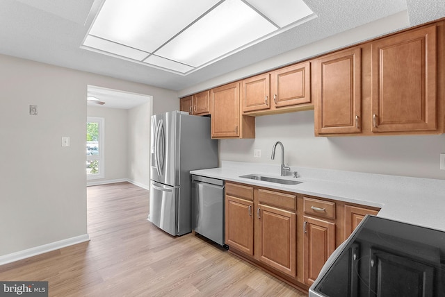 104 Drury Cir, Sterling, VA 20164 - kitchen with appliances with stainless steel finishes, light countertops, light wood-style floors, and brown cabinets