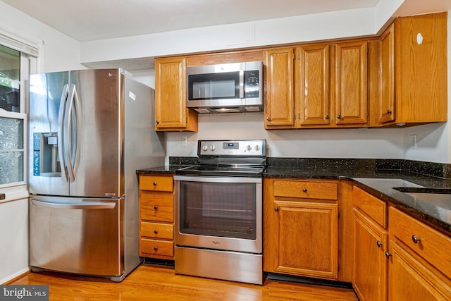 2843 Shepperton Ter, Silver Spring, MD 20904 - kitchen featuring stainless steel appliances, brown cabinetry, light wood finished floors, and dark stone countertops