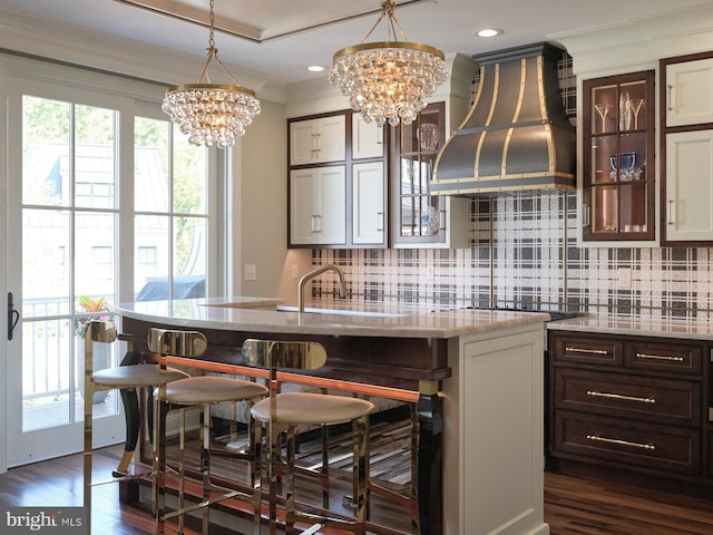 44 W Mechanic St, New Hope, PA 18938 - kitchen featuring custom exhaust hood, a chandelier, ornamental molding, a breakfast bar area, and tasteful backsplash