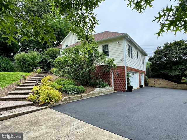 11608 Leesburg Pike, Herndon, VA 20170 - view of side of property with asphalt driveway, brick siding, an attached garage, and stairs
