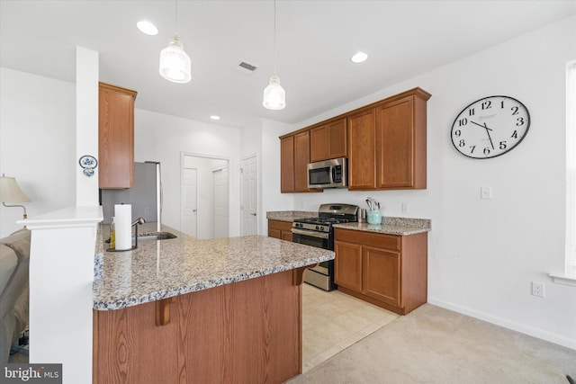 125 E Clarendon Dr, Smyrna, DE 19977 - kitchen featuring stainless steel appliances, a peninsula, a breakfast bar area, brown cabinets, and recessed lighting