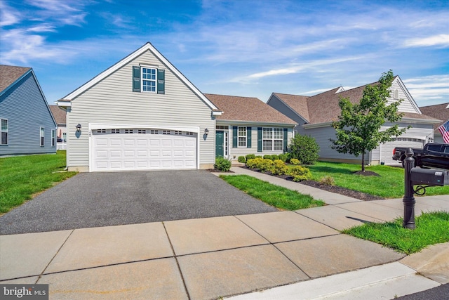 125 E Clarendon Dr, Smyrna, DE 19977 - traditional home featuring asphalt driveway, a front lawn, a garage, and roof with shingles