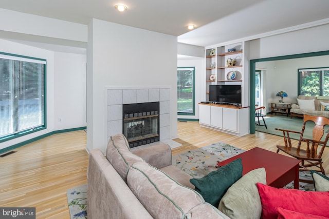 9 Sleepy Hollow Ln, West Windsor, NJ 08550 - living area with light wood finished floors, a tiled fireplace, and built in shelves