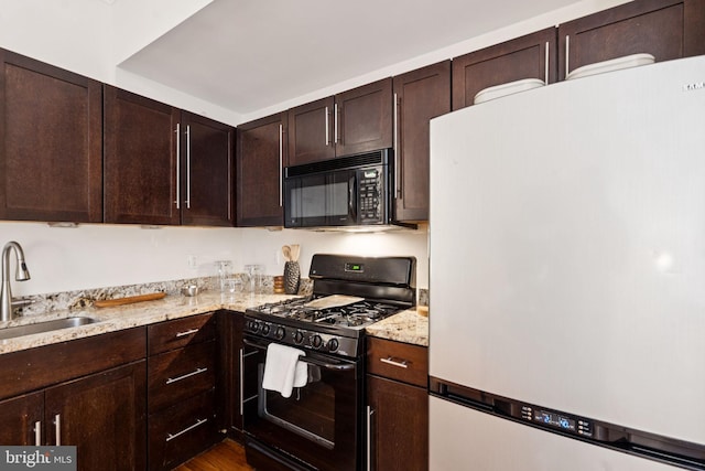 238 S 13th St Unit 1, Philadelphia, PA 19107 - kitchen featuring black appliances, dark brown cabinetry, light stone countertops, and dark wood-style floors