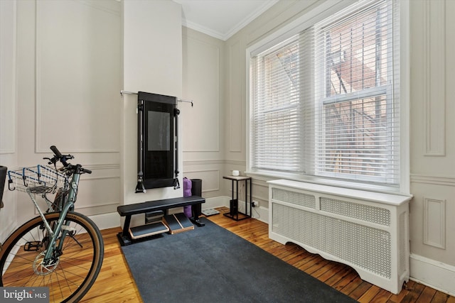 238 S 13th St Unit 1, Philadelphia, PA 19107 - exercise room with radiator heating unit, a decorative wall, wood finished floors, crown molding, and healthy amount of natural light