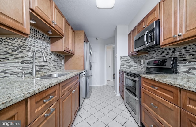 15100 Interlachen Dr Unit 4-207, Silver Spring, MD 20906 - kitchen with appliances with stainless steel finishes, light tile patterned floors, tasteful backsplash, and brown cabinetry
