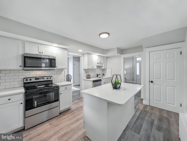 729 E Main St, Ephrata, PA 17522 - kitchen with stainless steel appliances, light countertops, white cabinets, and backsplash