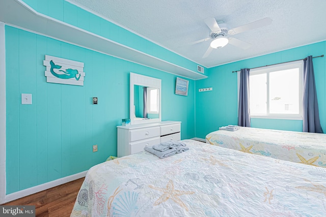 424 Lark Ln Unit E304, Ocean City, MD 21842 - bedroom with wood finished floors, multiple windows, a textured ceiling, and a ceiling fan